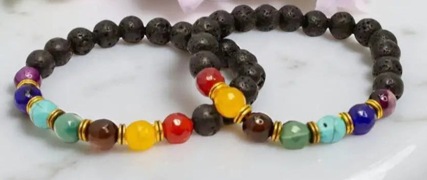 Two beaded chakra bracelets featuring black lava stone diffuser and essential oils
