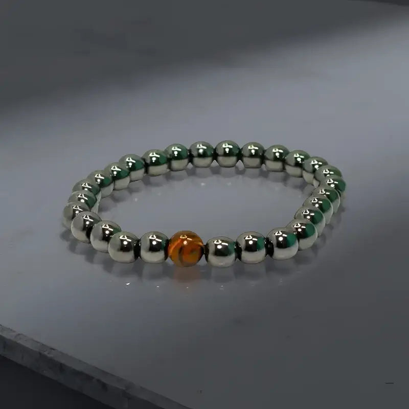 Silver beaded mens hematite bracelet with orange accent bead showcasing grounding properties