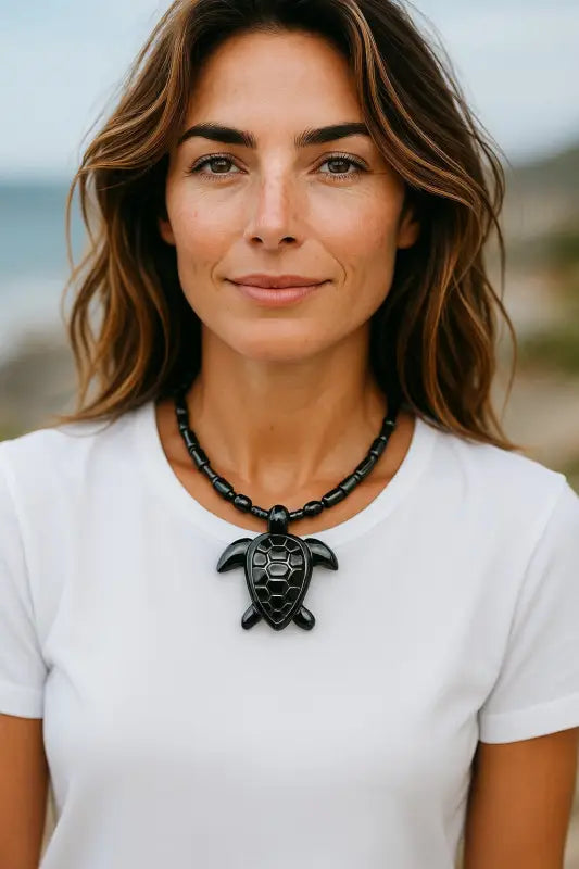 Hematite Turtle Necklace with unique charm worn by woman in white t-shirt for grounding